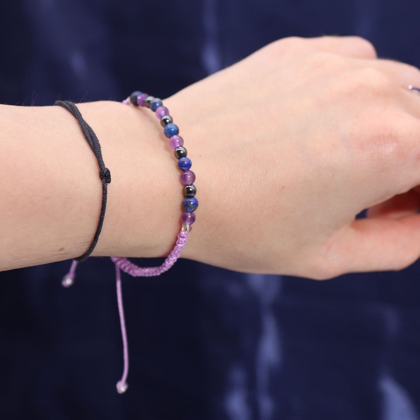 Aquarius astrology candle with crystals by Samsara Wellbeing featured with colourful beaded bracelet on wrist