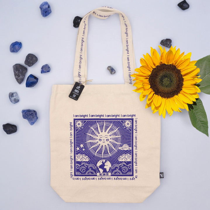 Hop Hare tarot bag UK with celestial sun and earth design printed on natural cotton tote surrounded by crystals and sunflower