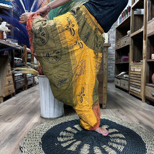 Samsara Wellbeing Aladdin style yoga pants in multicolour patchwork with artistic prints worn during yoga stretch indoors