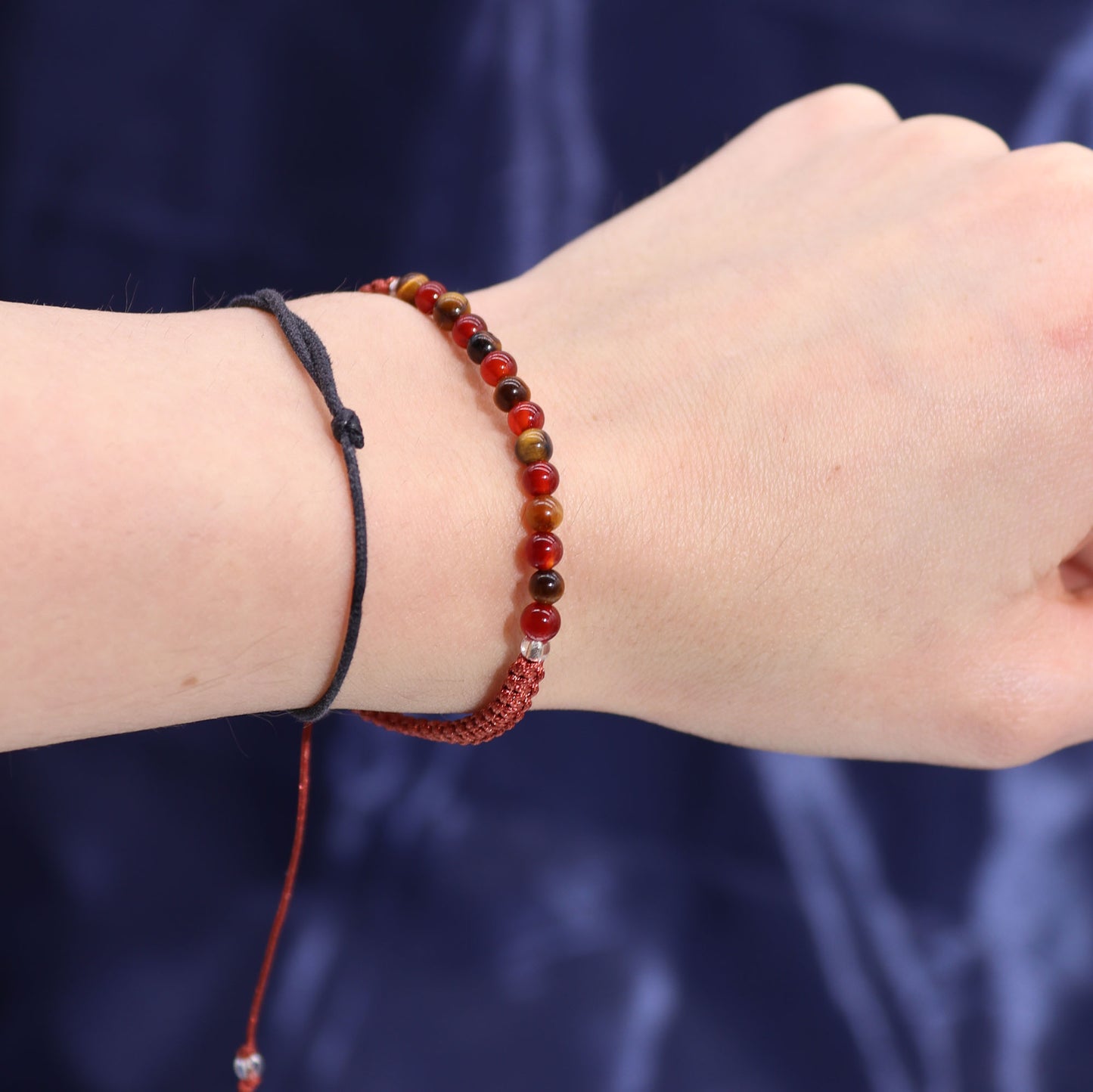 Leo zodiac crystal candle from Samsara Wellbeing displayed with handmade beaded bracelet on wrist