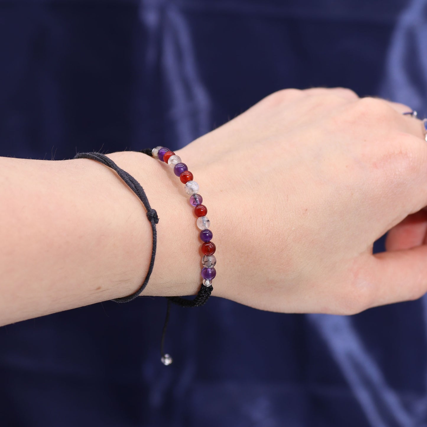Virgo zodiac crystal candle by Samsara Wellbeing displayed alongside purple and red beaded bracelet on wrist