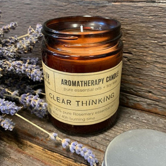 Clear Thinking aromatherapy soy wax essential oil candle in brown glass jar with lavender on wooden surface