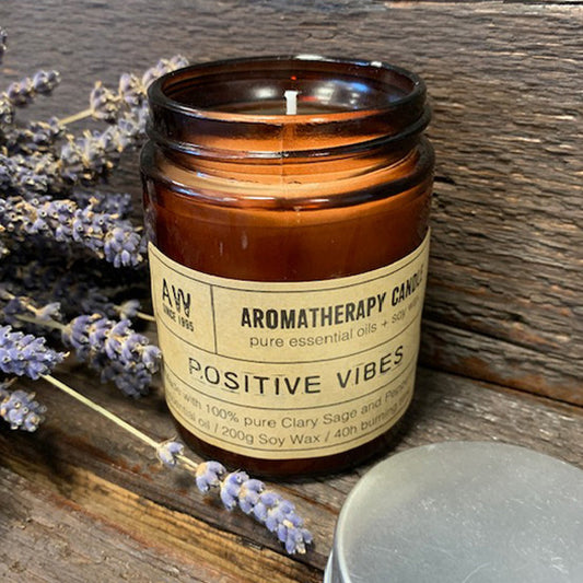 My Store soy wax candle with essential oils in amber jar labelled Positive Vibes with lavender sprigs