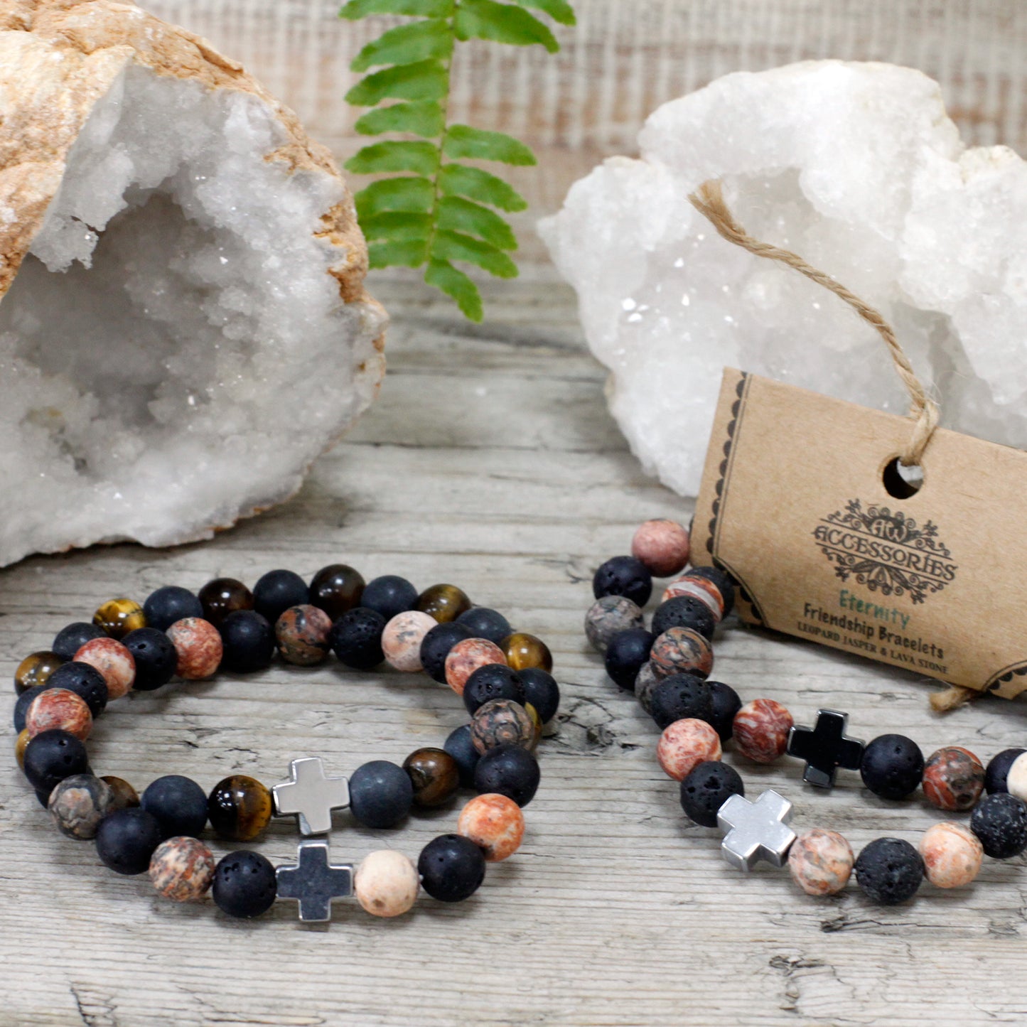 Gemstone friendship bracelets with black cross beads displayed on wooden surface with crystal geodes