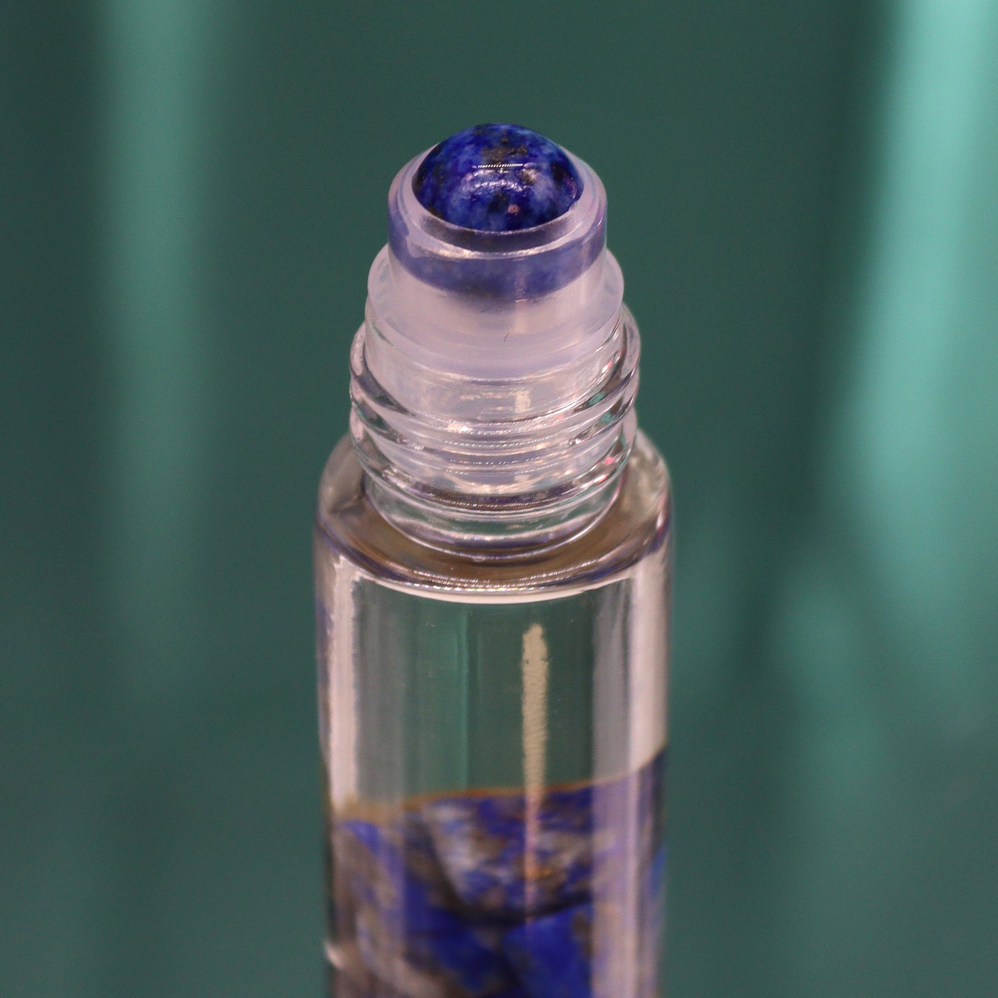 Close-up of a crystal infused essential oil roller bottle with a blue crystal rollerball