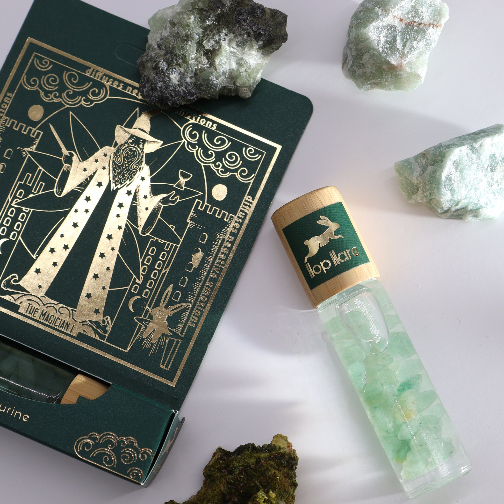 Tarot essential oil roll on with green stones and gold decorated tarot card packaging