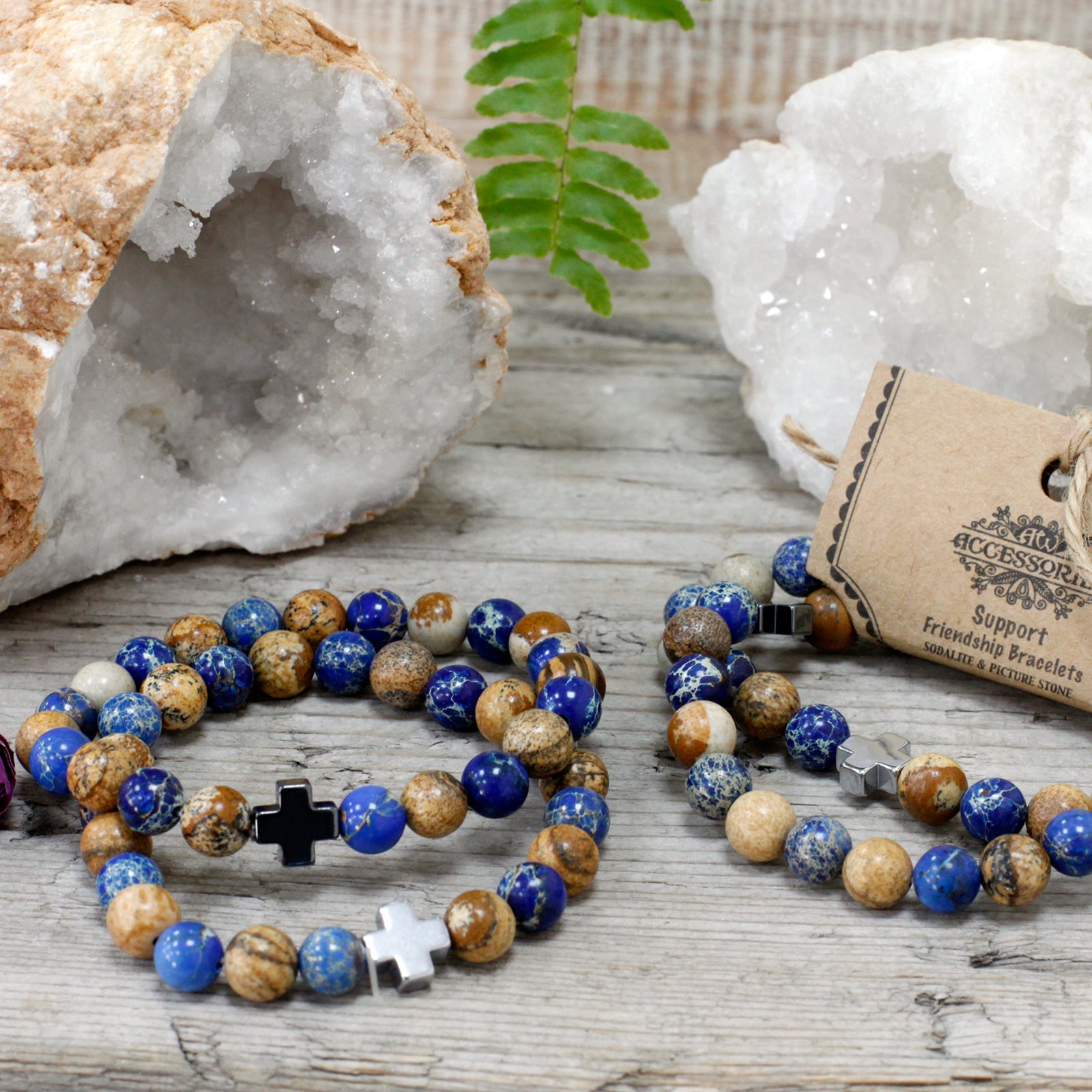 Gemstone friendship bracelets set with blue and brown beads and cross charms on a wooden surface