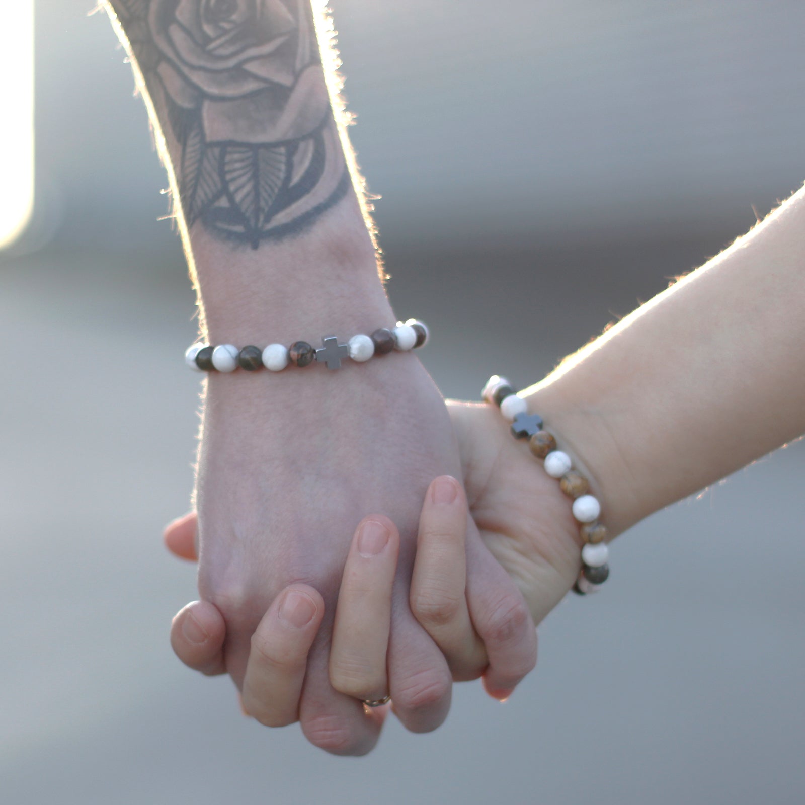 Gemstone friendship bracelets set worn on adult and child wrists holding hands outdoors