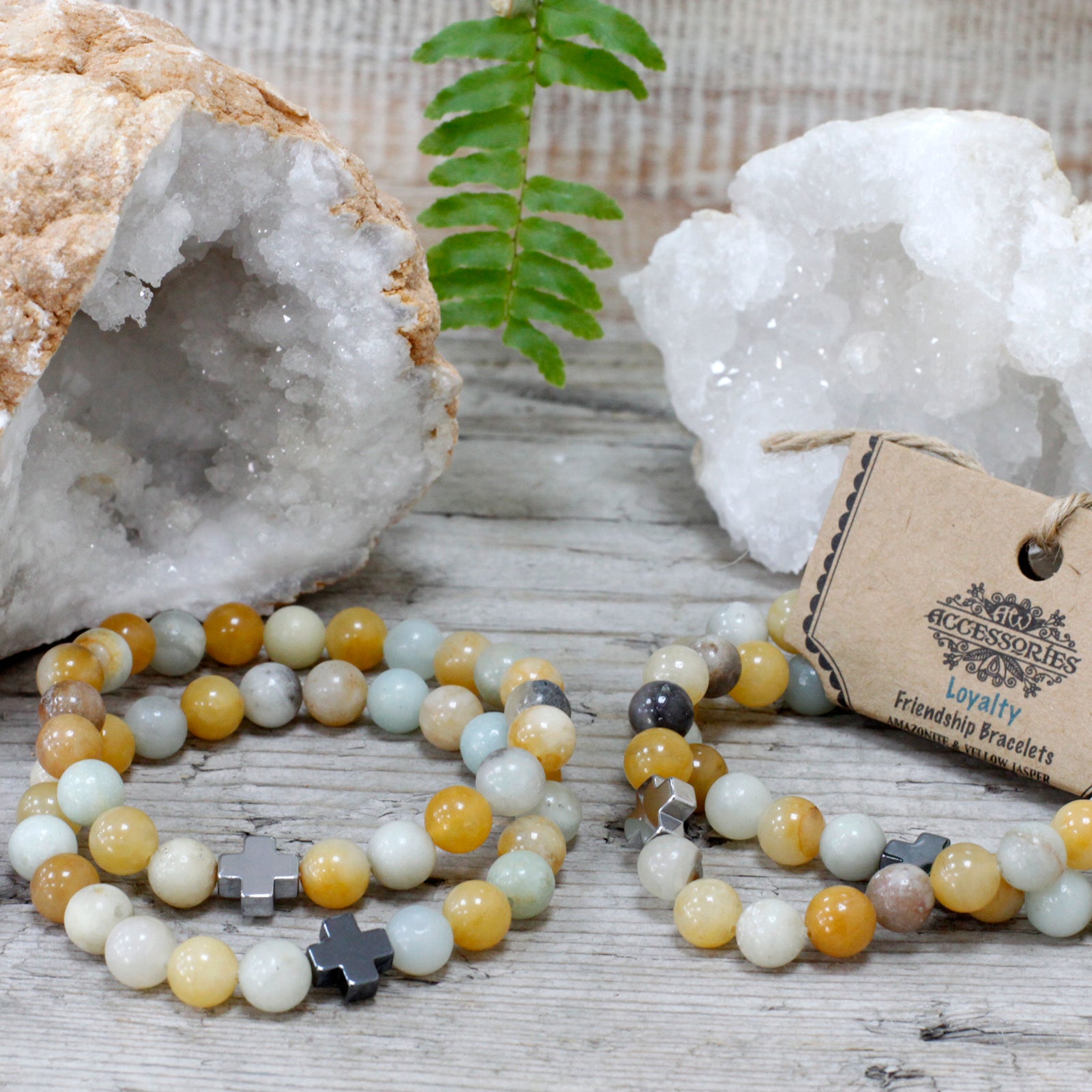 Gemstone friendship bracelets set with yellow and white beads and cross charms displayed with crystals