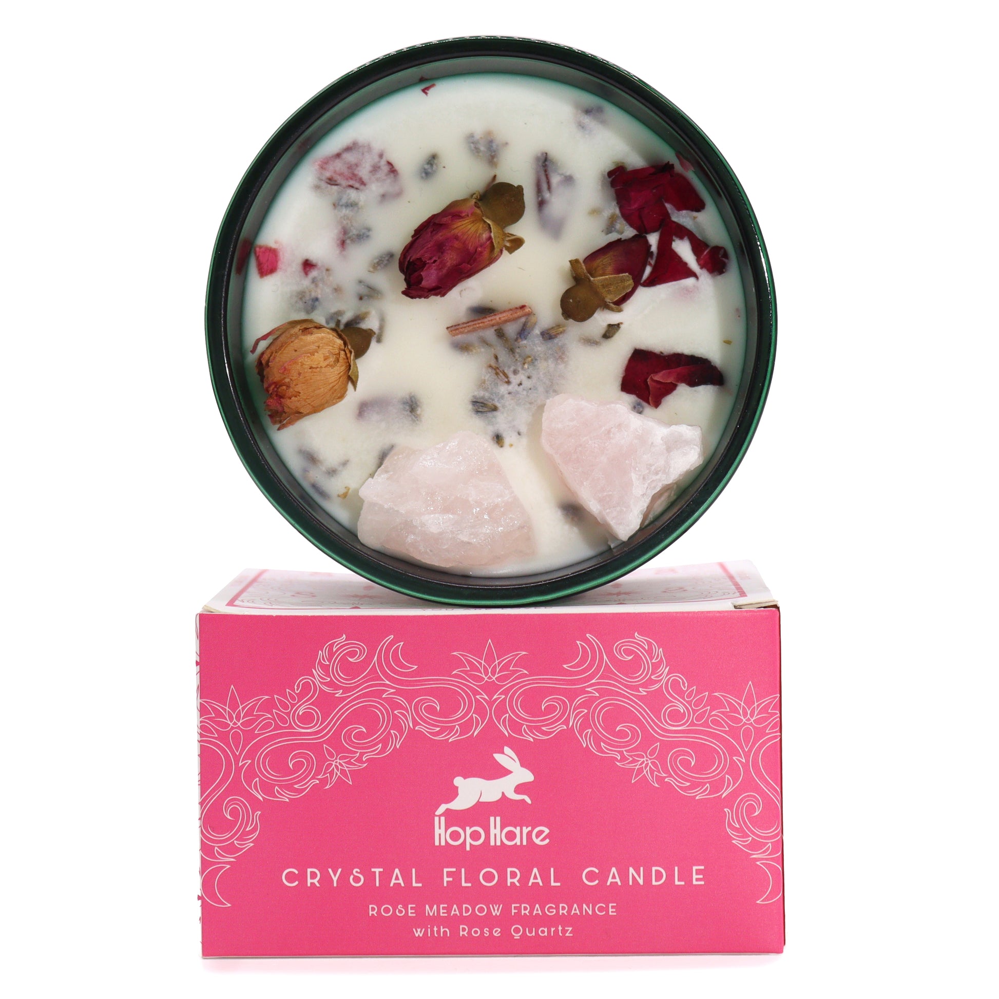 Crystal magic flower candle with rose quartz and dried petals in a green tin on a pink decorative box