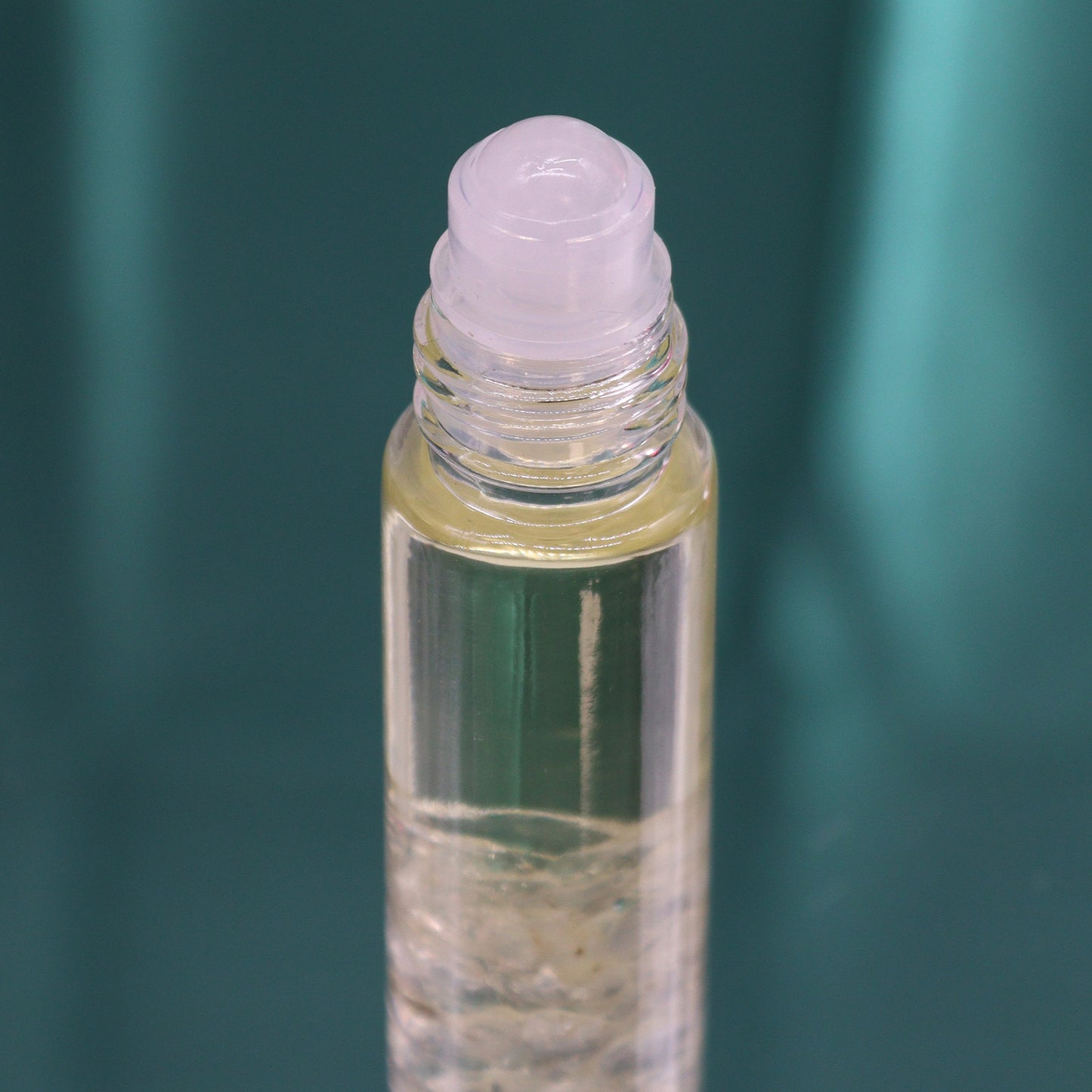 Close-up of clear glass bottle with rollerball applicator containing tarot inspired roll on oil