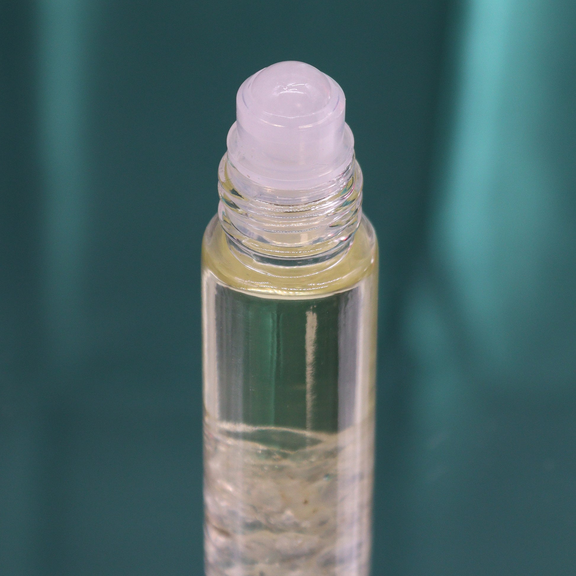 Close-up of clear glass bottle with rollerball applicator containing tarot inspired roll on oil