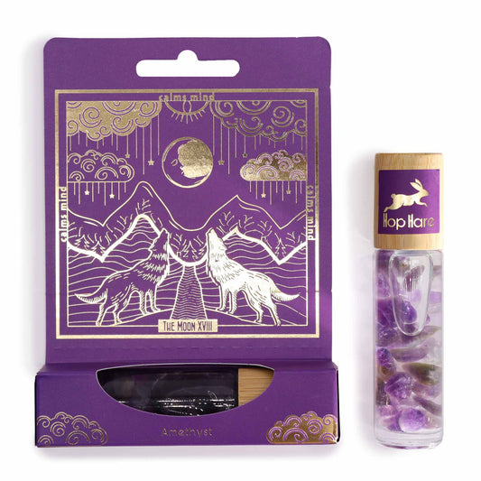 Tarot moon essential oil roll on with amethyst crystals in a glass bottle and purple tarot-themed packaging