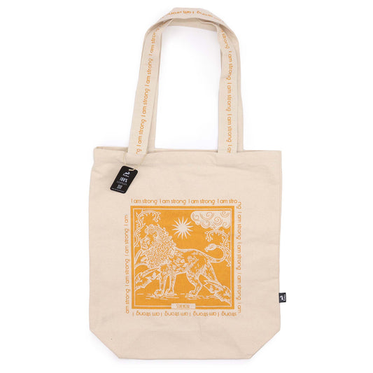 Beige motivational tote bag with orange lion design and I am strong text on straps and front