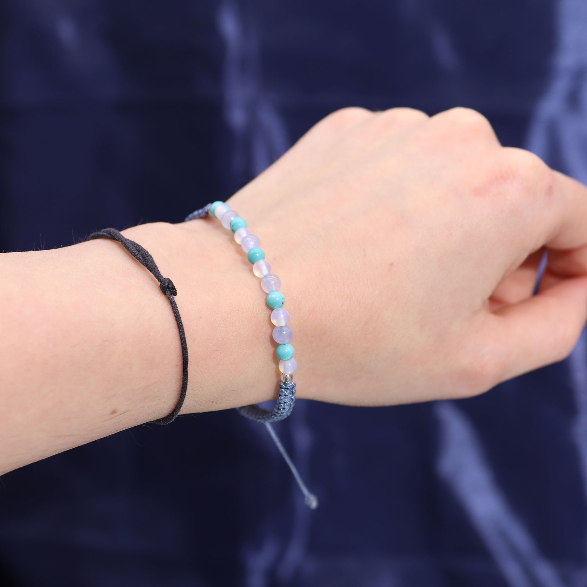 Pisces crystal candle from Samsara Wellbeing featuring soothing pastel beads on wrist bracelet