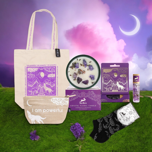 Spiritual self care gift set with tote bag, pouch, crystal floral candle, incense, matches, and socks displayed on grass