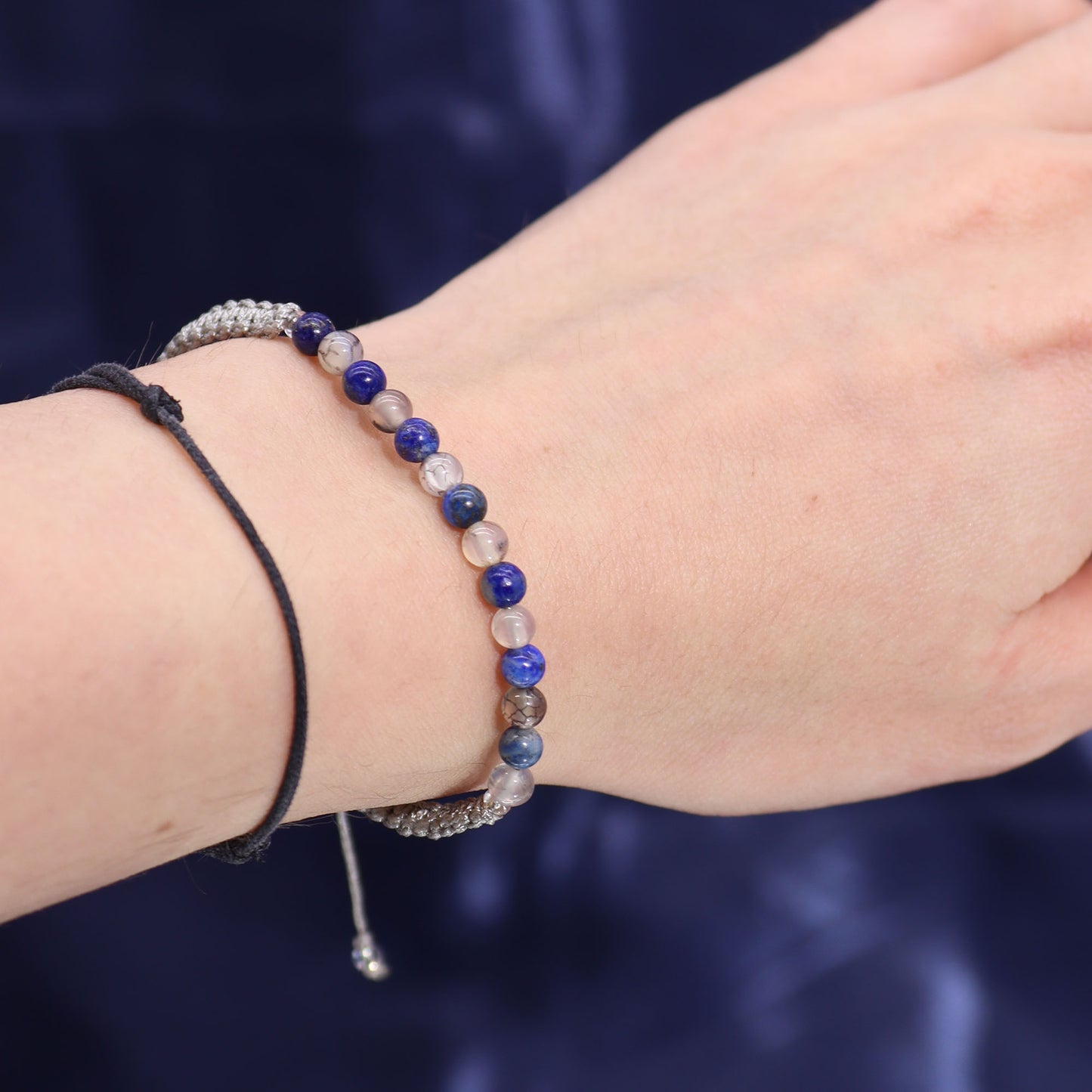 Taurus zodiac crystal candle by Samsara Wellbeing featuring a bracelet with blue and neutral beads on wrist