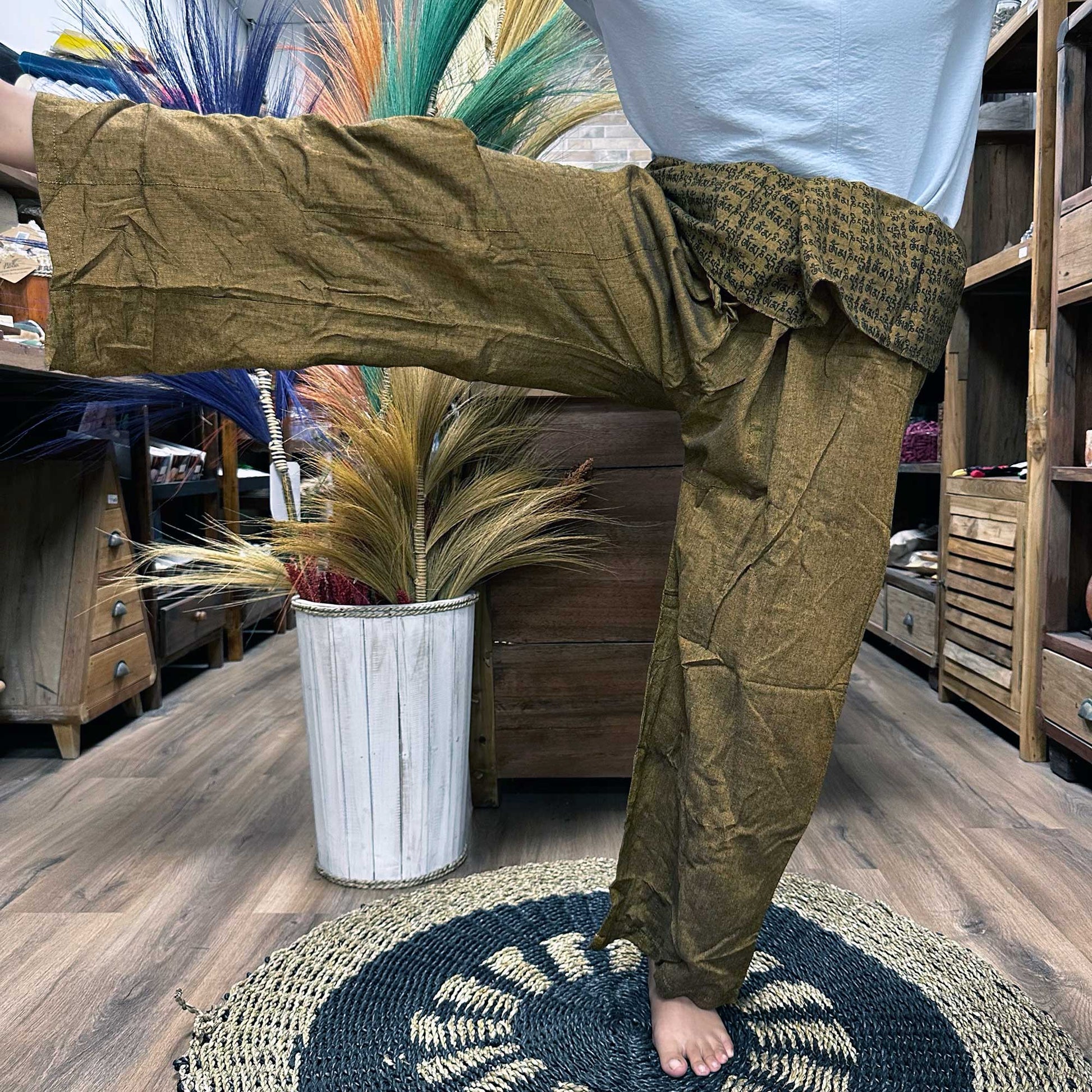 Samsara Wellbeing brown Thai fisherman pants for yoga with wide legs and adjustable waist shown indoors