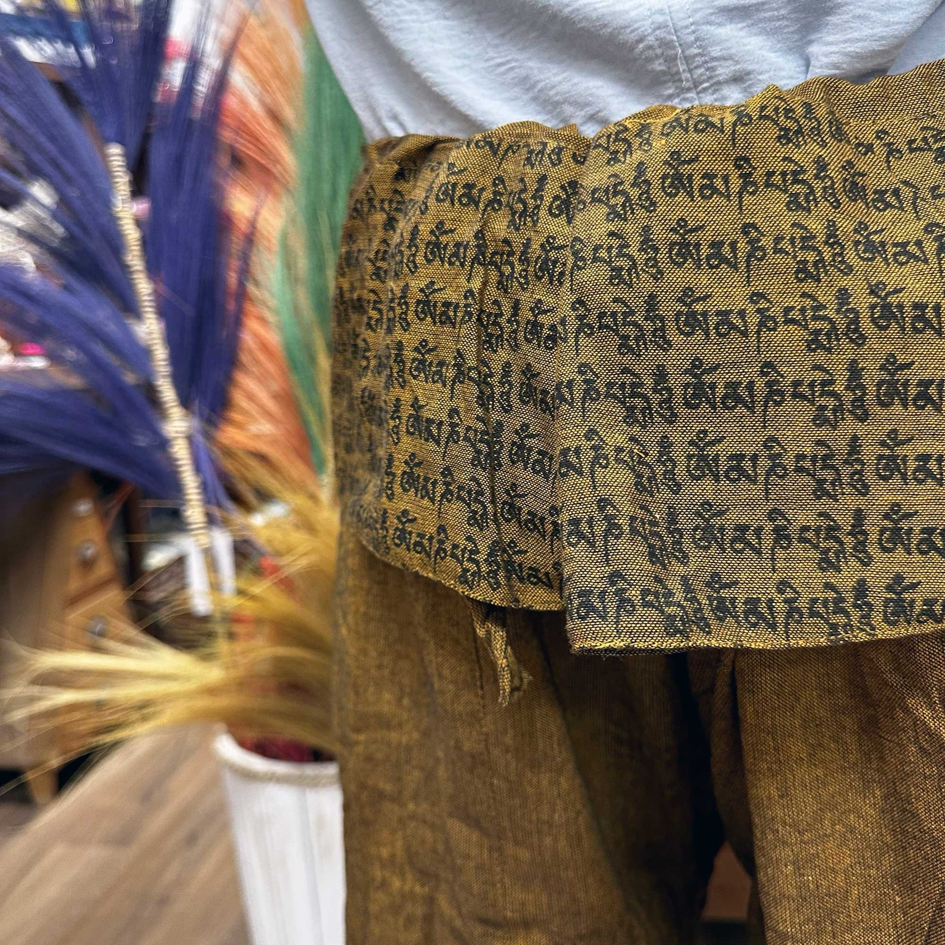 Brown Thai fisherman pants for yoga with black script design on fabric waist by Samsara Wellbeing