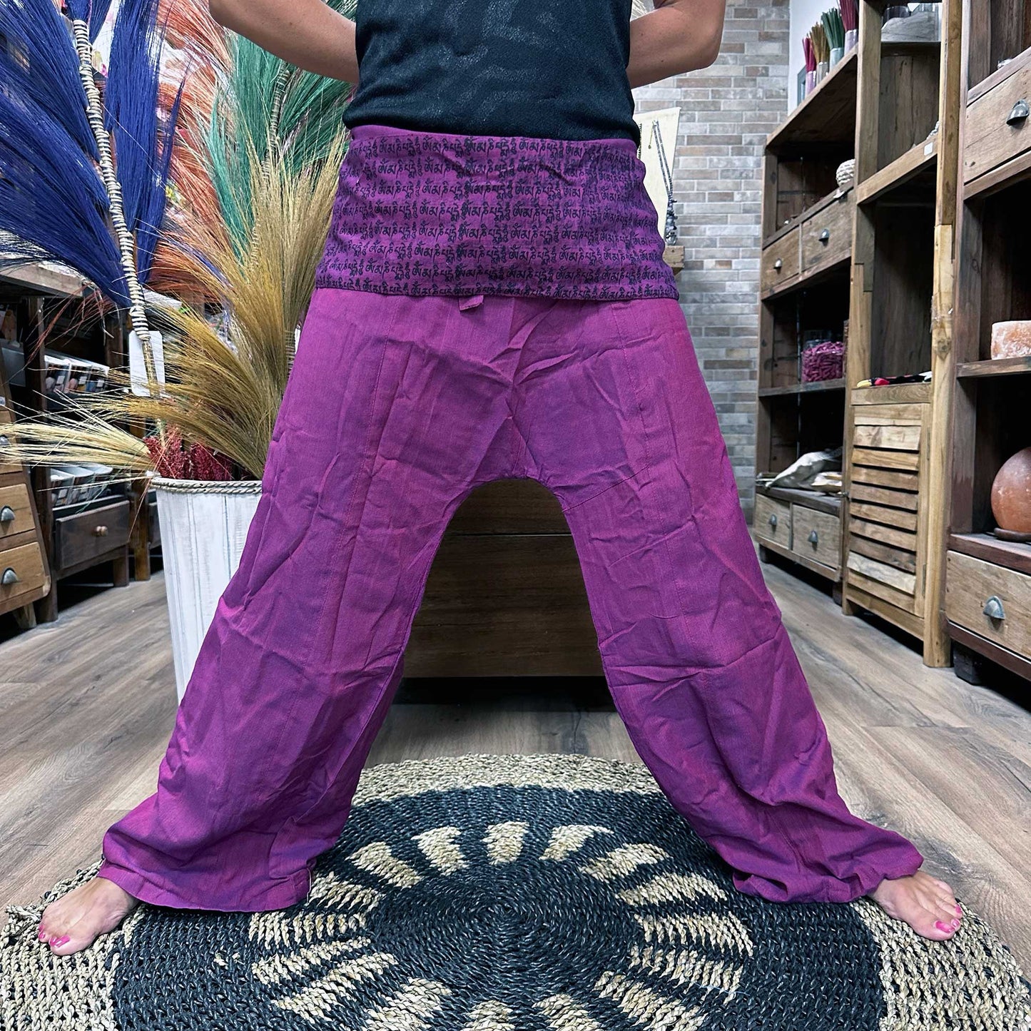 Purple Thai fisherman pants with wide legs and high waist worn indoors on a decorative rug