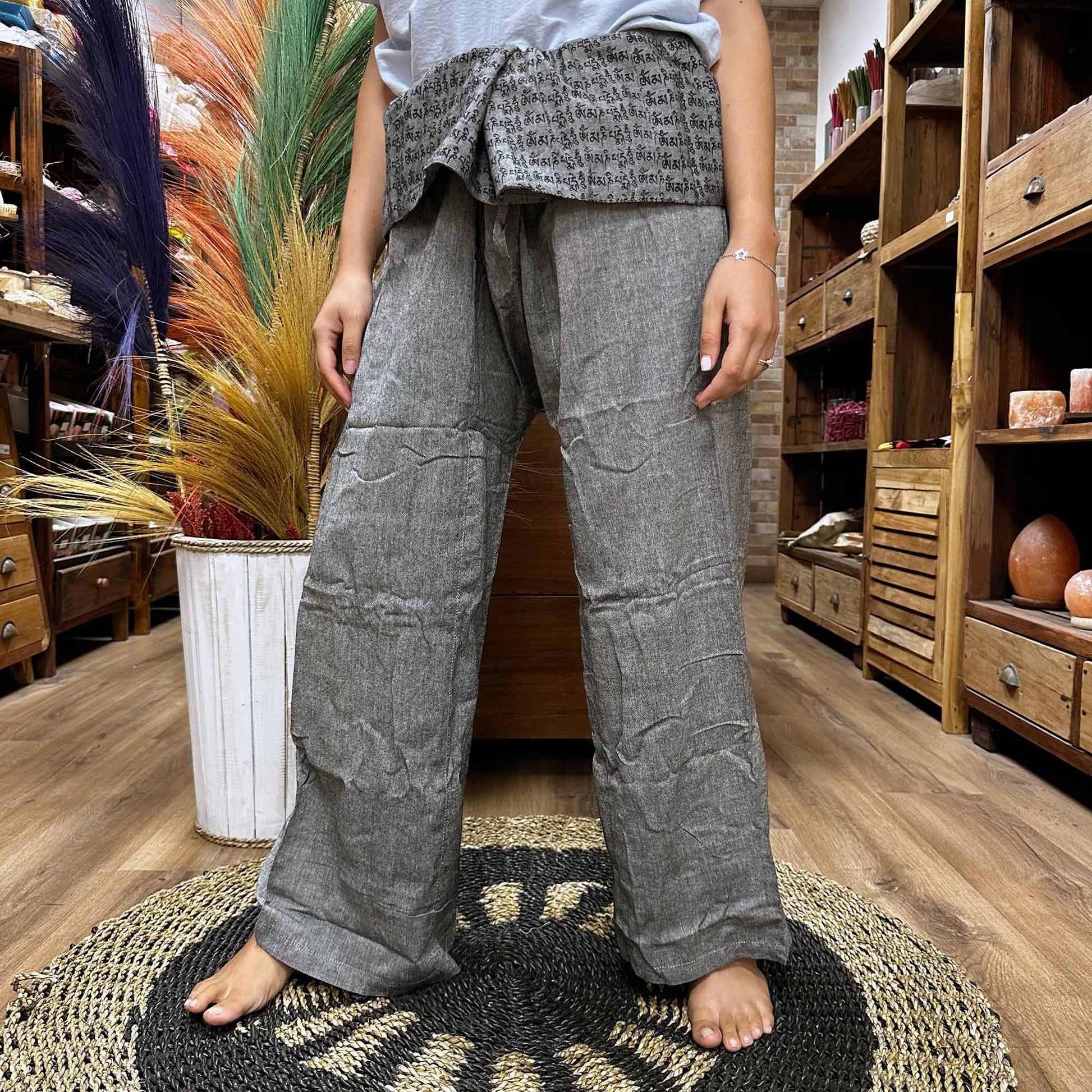 Samsara Wellbeing grey Thai fisherman yoga pants worn barefoot in a wooden store setting