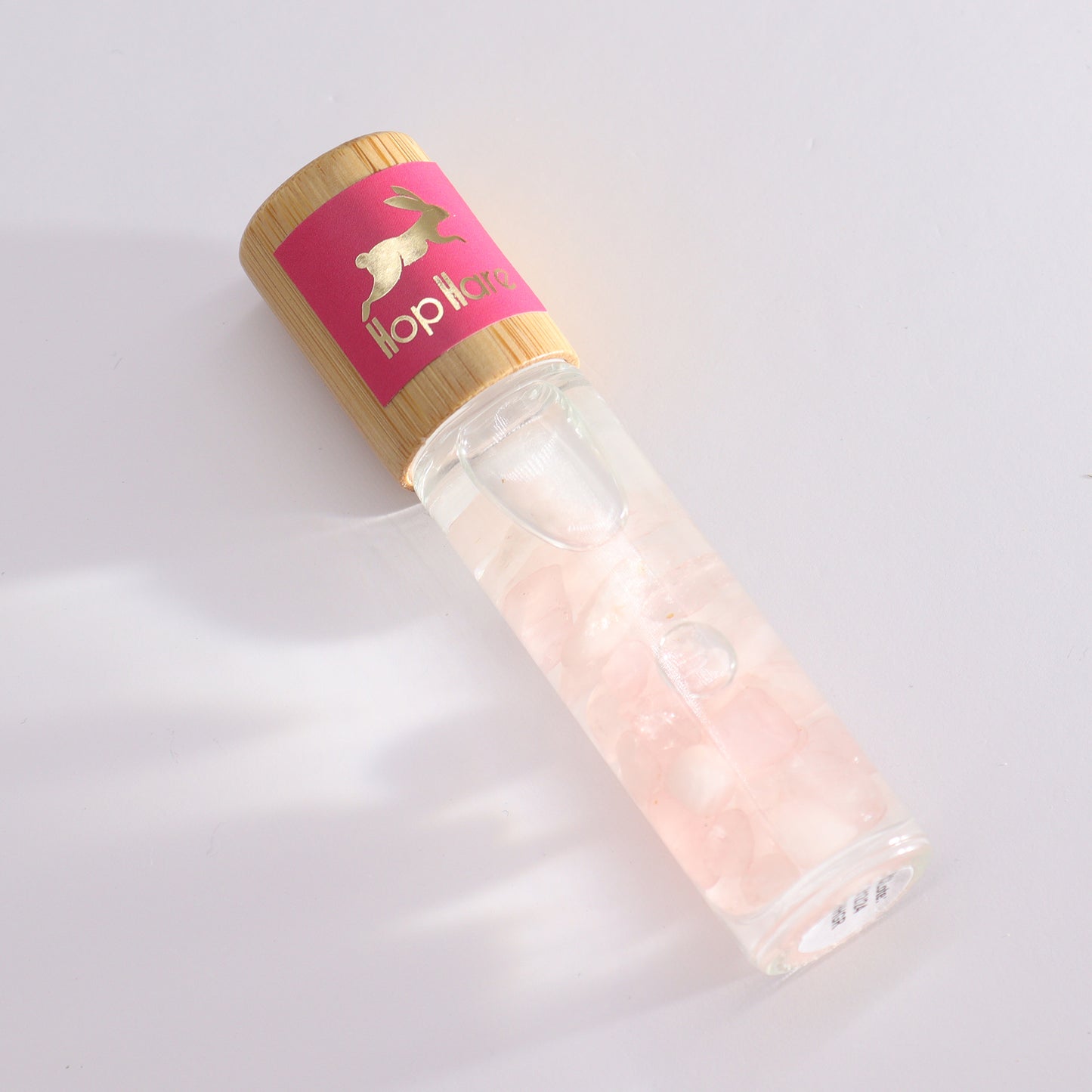The lovers aromatherapy roller with pink stones in clear glass bottle and bamboo cap