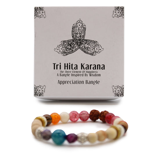 Tri Hita Karana bangle with multicolored beads displayed alongside decorative packaging box