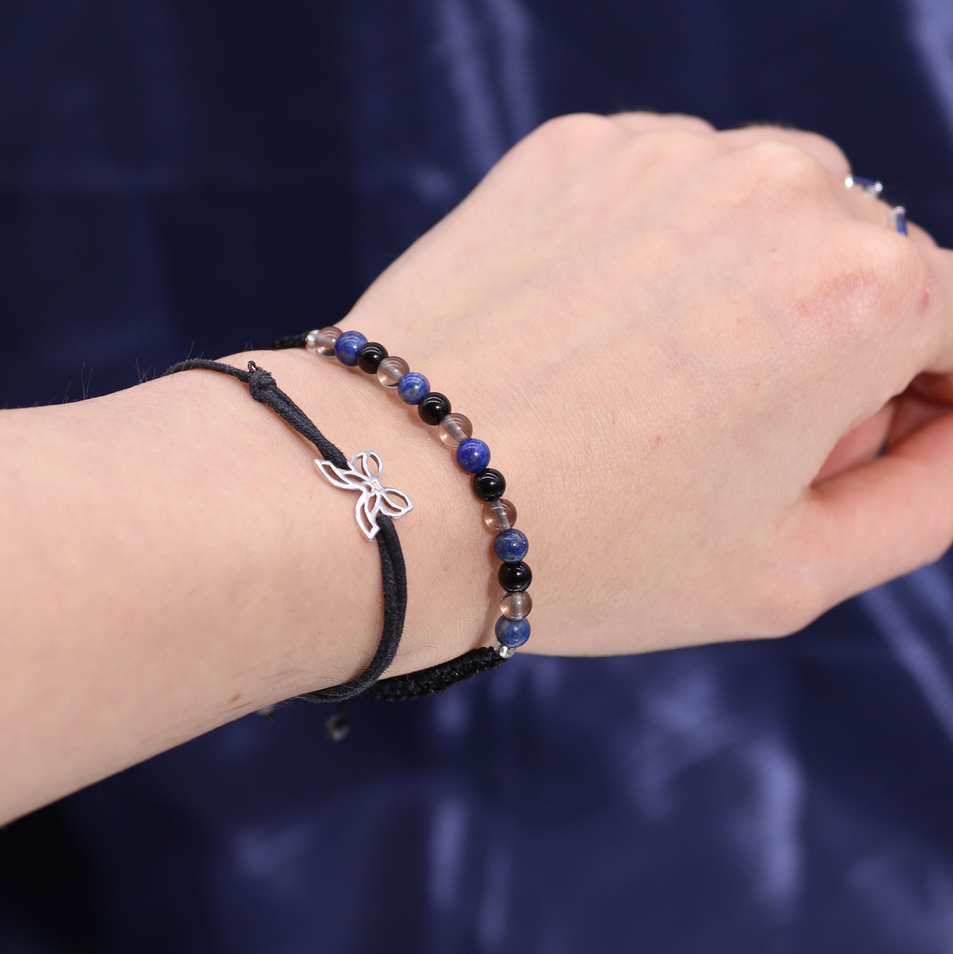 Scorpio zodiac crystal candle by Samsara Wellbeing displayed with beaded and ribbon bracelets on wrist