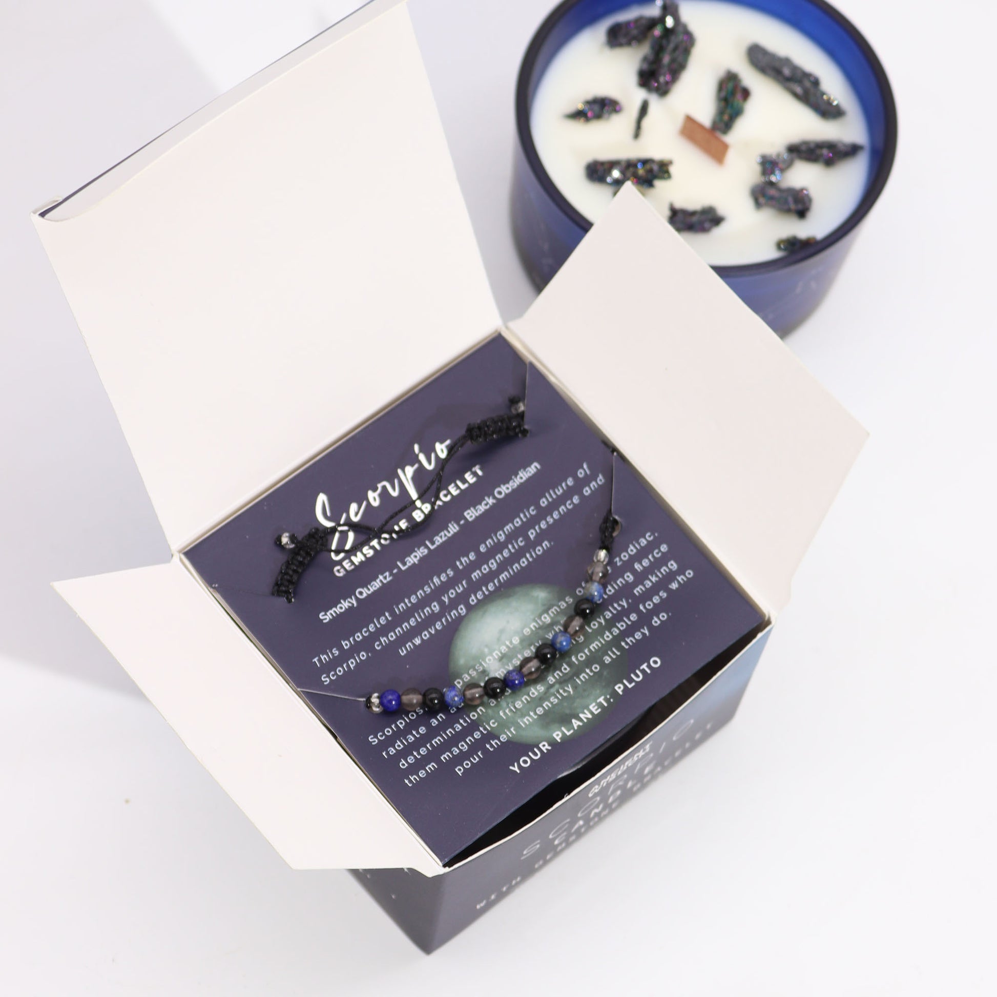 Scorpio zodiac crystal candle by Samsara Wellbeing with decorative stones and a constellation bracelet